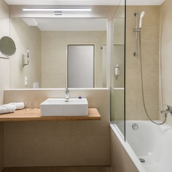 A Standard Plus szoba kényelmes kanapéval és modern berendezéssel várja a vendégeket, tökéletes választás balatoni kikapcsolódáshoz.